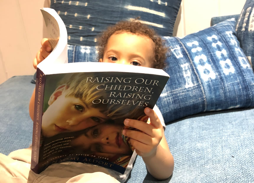 Child lying down reading, Raising Our Children, Raising Ourselves child, reading, learning